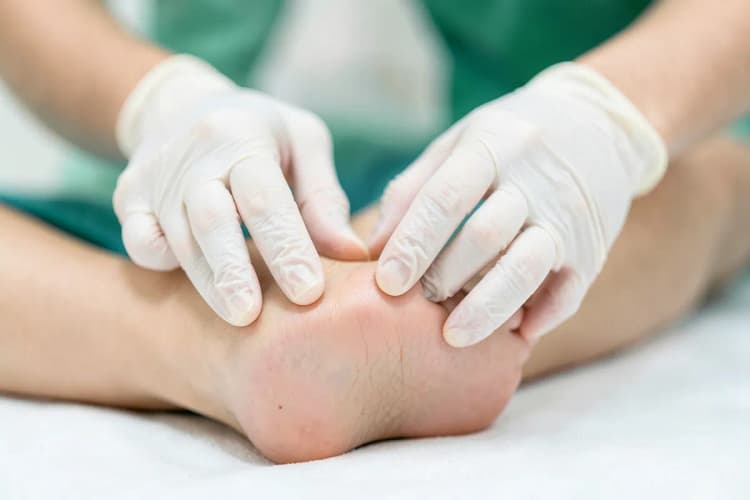 Mãos de massoterapeuta aplicando pressão em um pé